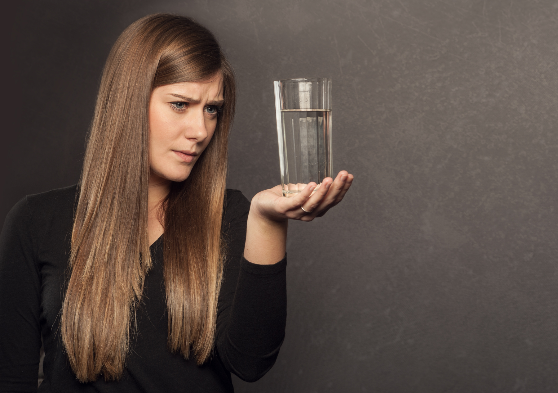 photo of woman looking at glass of water