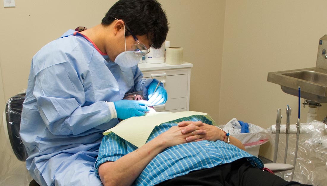 Fourth-year dental student Ethan Yang treats a patient at North Dallas Shared Ministries in June 2014.