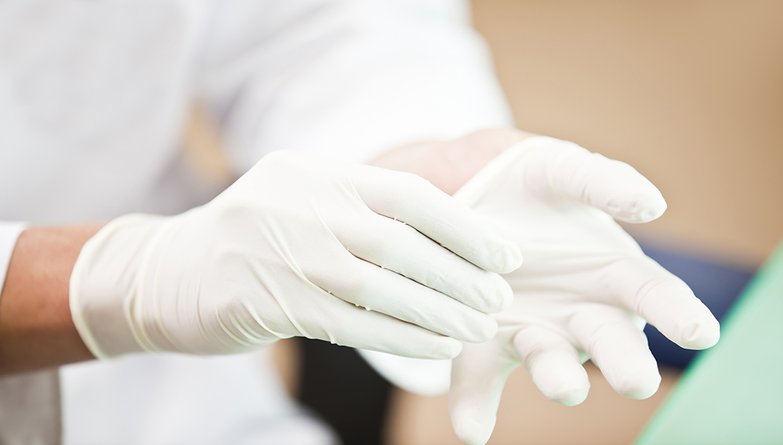 Doctor putting on examination gloves