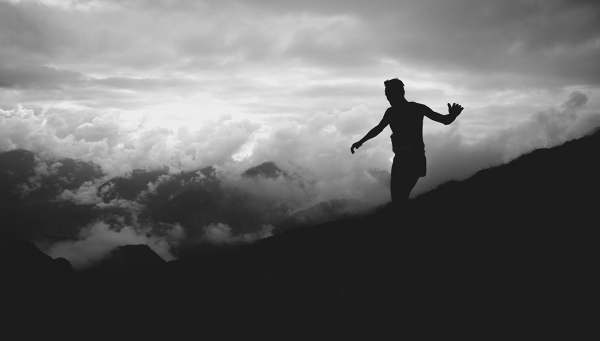 Silhouette of a person walking on the top of a mountain