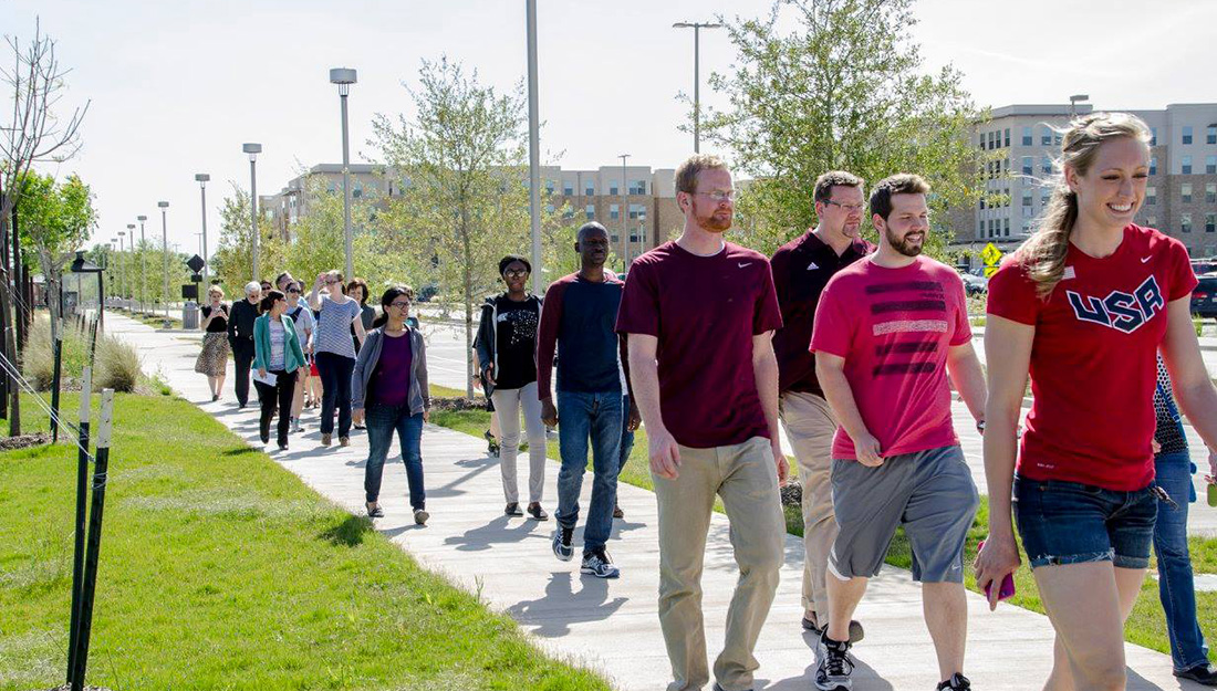 Students and faculty walk around their building to manage stress