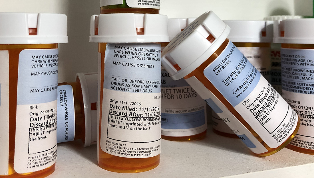 A close-up image of prescription pill bottles in medicine cabinet