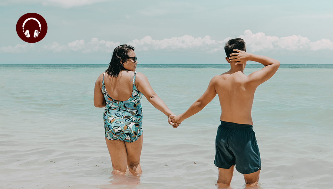 Is it bad to sit in a wet bathing suit too long?_Yeast infection_a man and a women, both wearing bathing suits, hold hands and walk into the ocean.