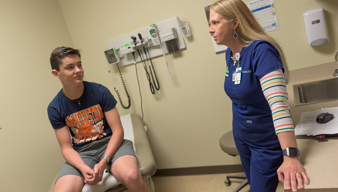 The importance of sports physicals-a nurse is speaking with a male teenager about his medical history during a sports physical