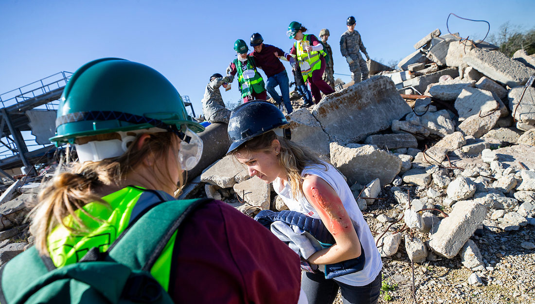health students assist mock patients from rubble