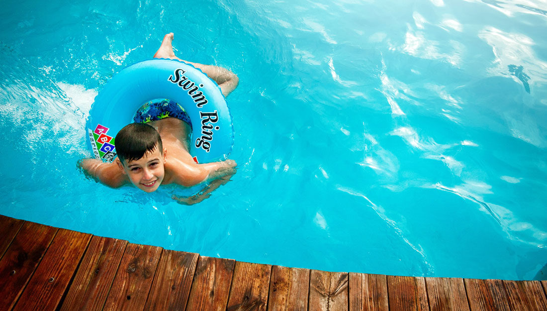 boy floating in pool with water ring