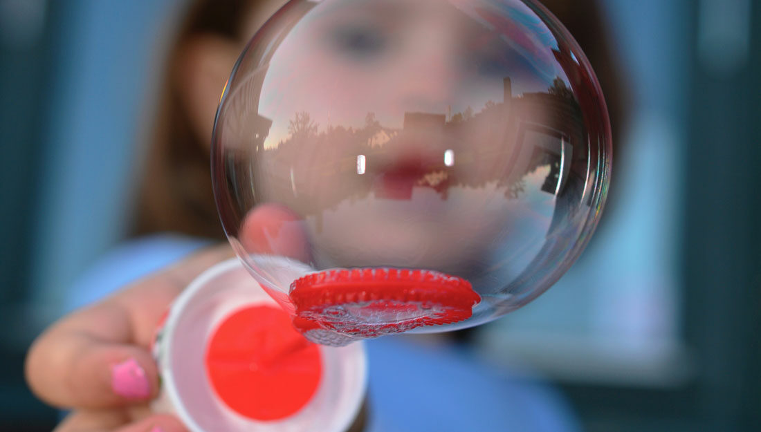 child holds a bubble close to camera