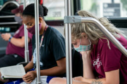 college students wearing masks ride bus