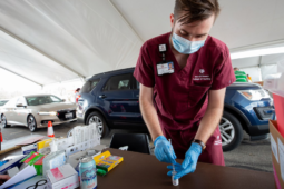 a nursing student loads a syringe with the Moderna COVID-19 vaccine at a drive-through vaccine clinic in Bryan-College Station