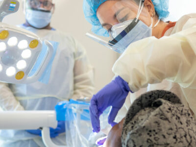graduate dental students assists professor at an off-site clinic