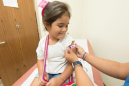 young child receives a bandaid on her arm after being vaccinated