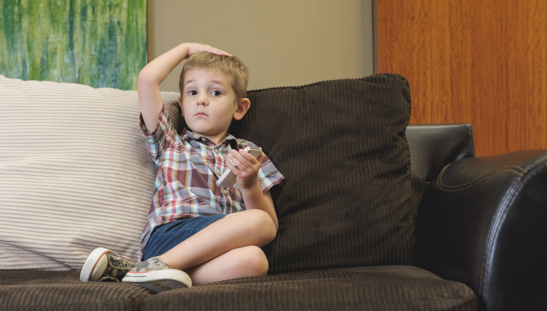 child on couch playing with cell phone