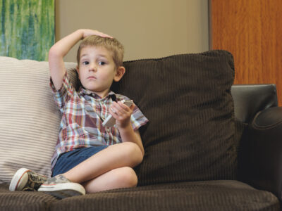 child on couch playing with cell phone