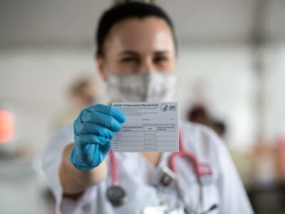 nursing student holds up a vaccination record card