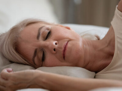 older woman sleeping on pillow in bed