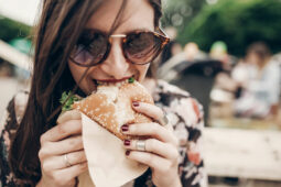 woman holding burger and eating