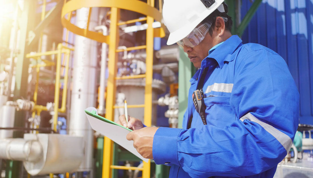 man working in petroleum refinery plant to check equipment marks a check list